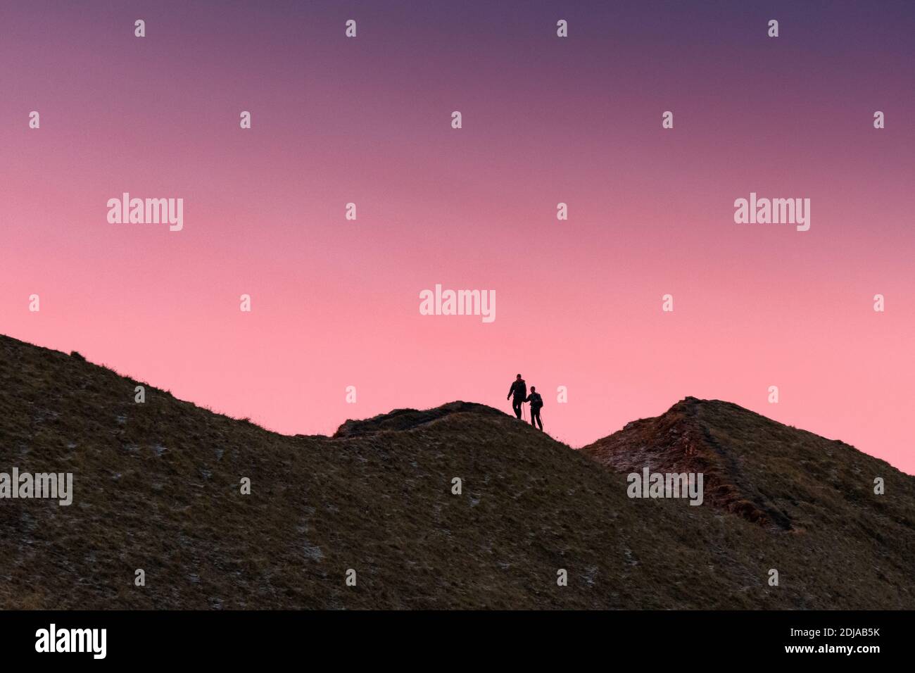 silhouette di escursionisti su una cresta svizzera durante un colorato alba Foto Stock