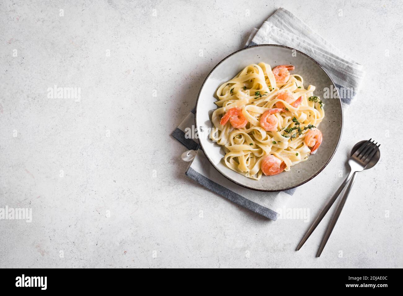 Pasta di fetticcine di gamberetti. Pasta italiana con gamberi e crema salsa alfredo, vista dall'alto, spazio copia. Foto Stock