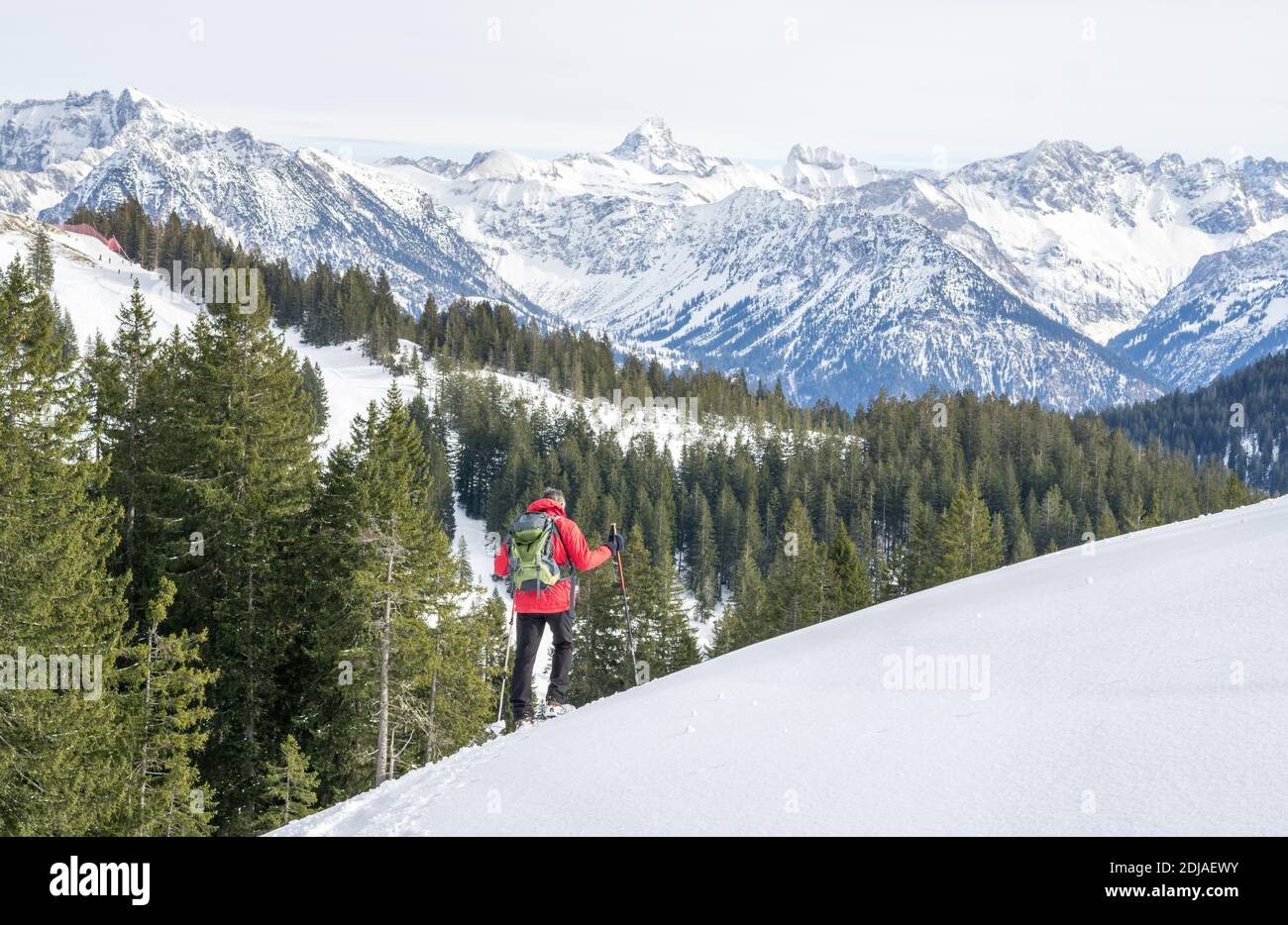 L'uomo anziano è l'escursionismo con racchette da neve nelle montagne alpine innevate. Allgau, Baviera, Germania. Foto Stock