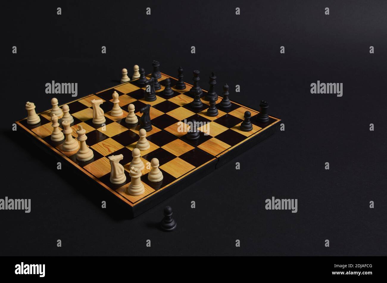 scacchi con una partita iniziata. Il bianco iniziò con la scommessa di una regina e il nero catturò due pedine. Foto Stock