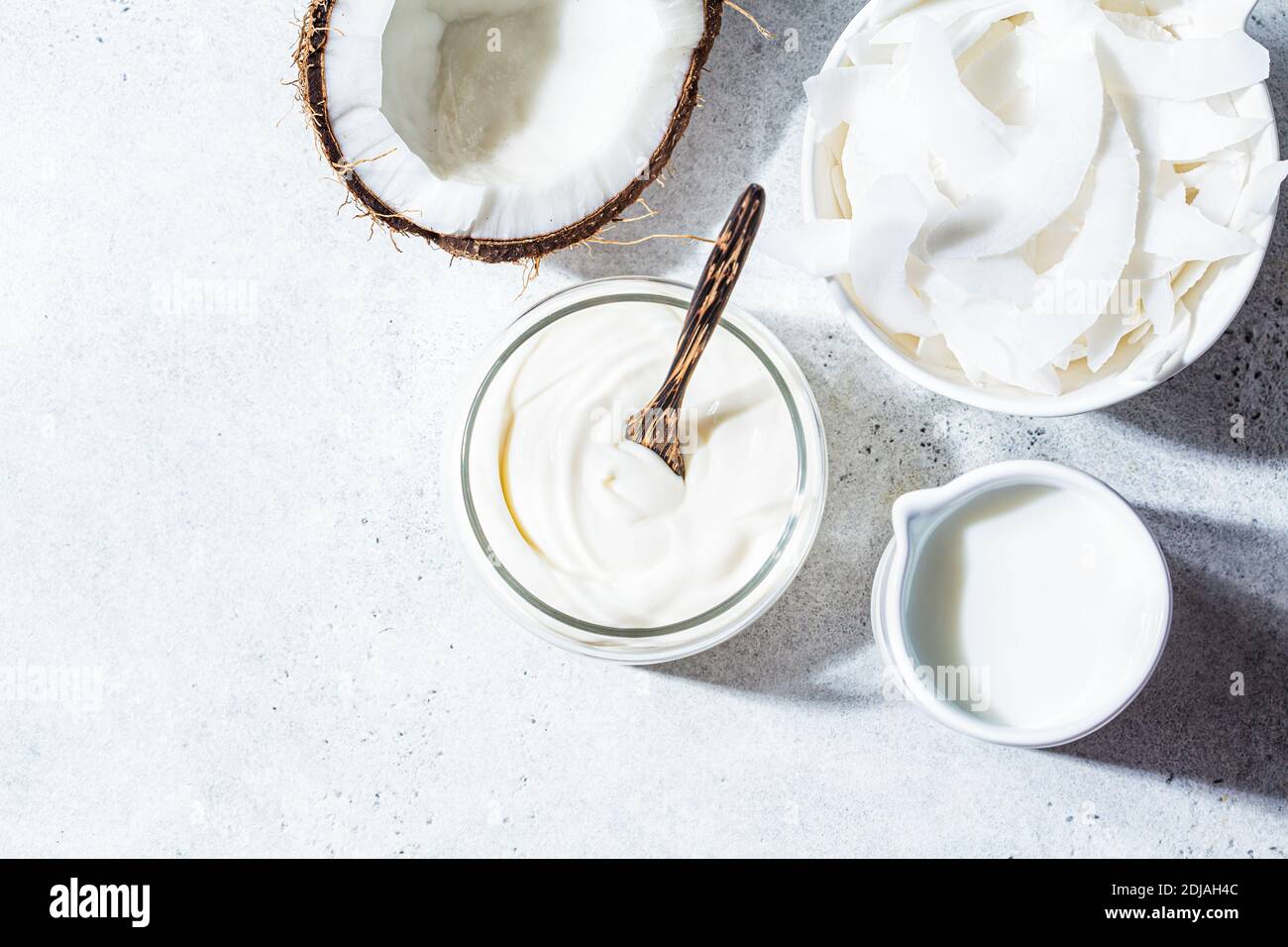 Prodotti vegani di cocco - latte, yogurt e patatine, sfondo bianco. Foto Stock