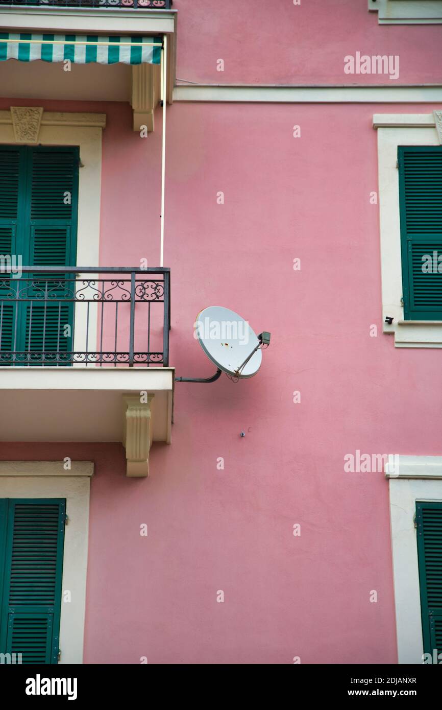 un edificio rosa con una parabola satellitare Foto Stock