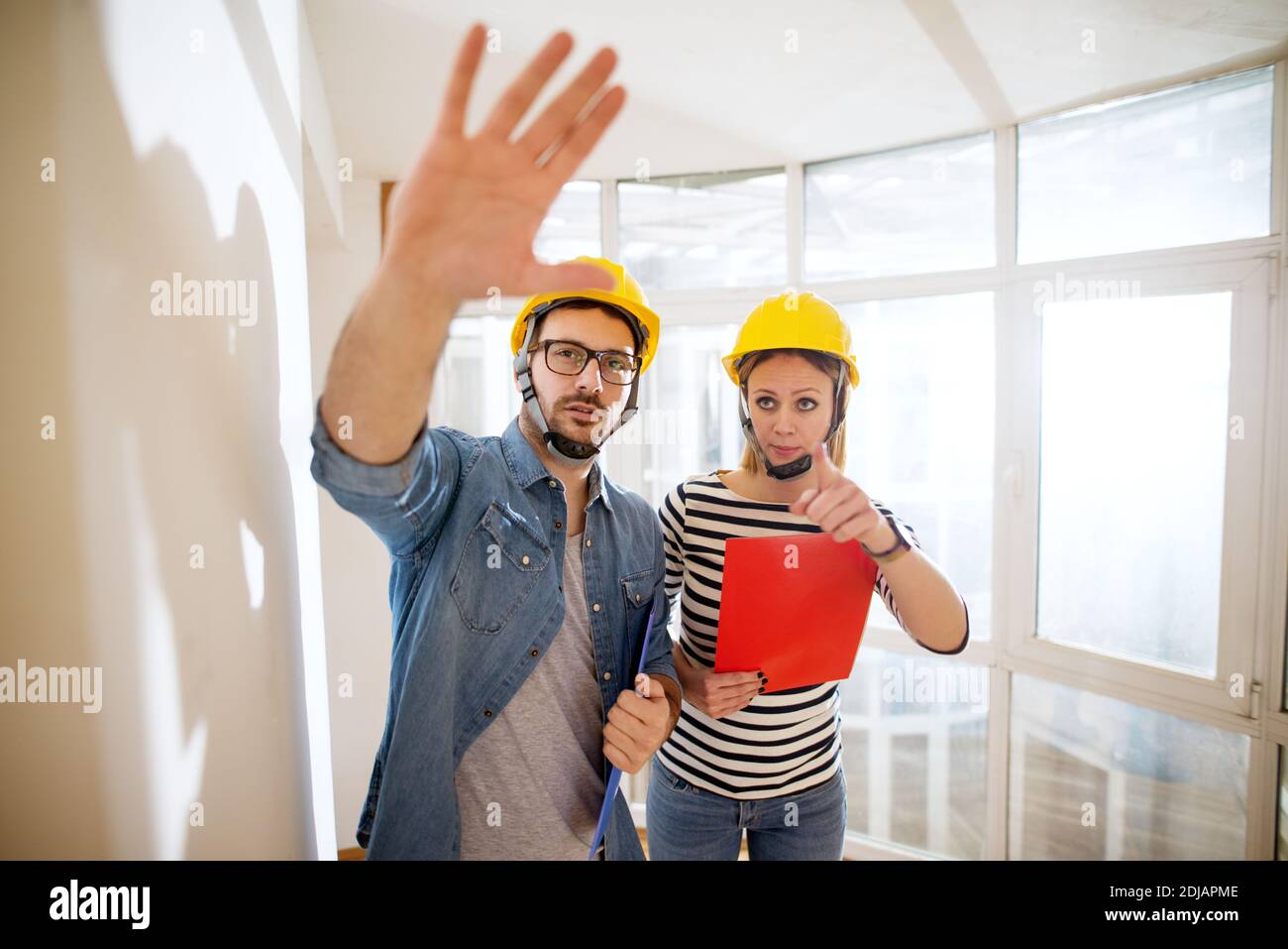 Un paio di bellissimi giovani ingegneri con caschi per discutere il prossimo passo. Foto Stock