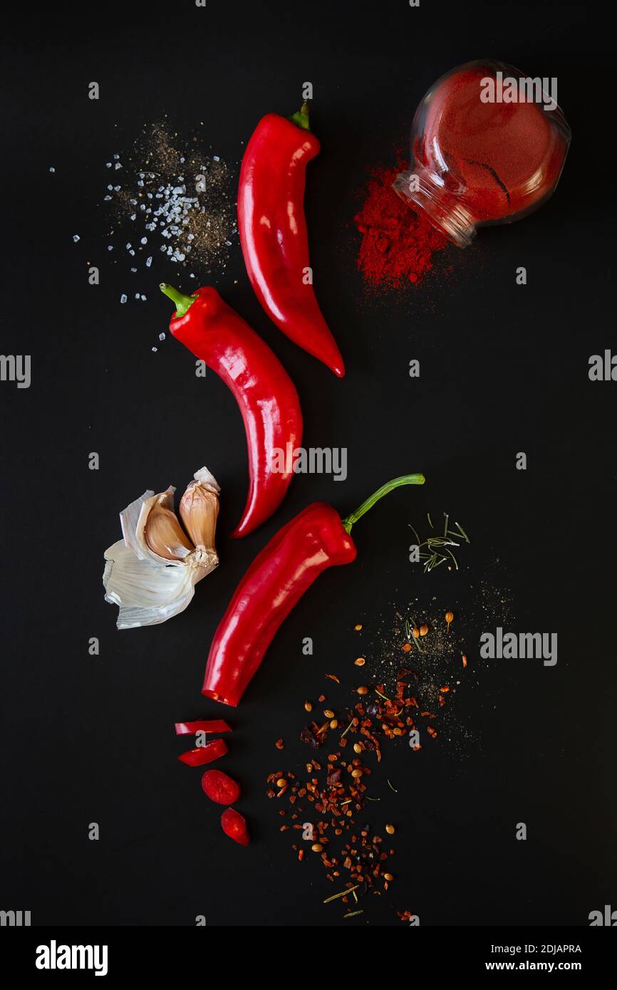 Peperoni rossi dolci, aglio e spezie su sfondo nero. Opuscolo promozionale e poster. Foto Stock
