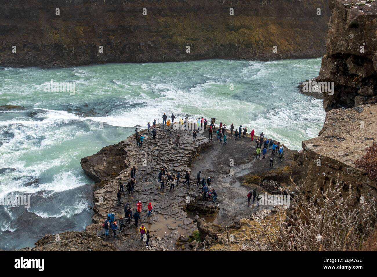 I turisti si trovano vicino al fiume Hvítá, nella parte delle cascate di Gullfoss Tour del cerchio d'oro in Islanda Foto Stock