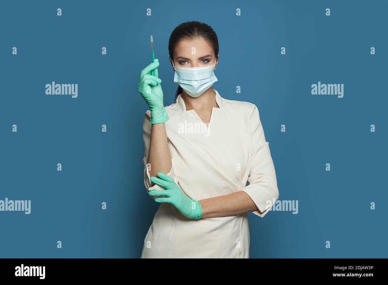 Concetto di vaccinazione. Medico o infermiere con siringa su sfondo blu Foto Stock