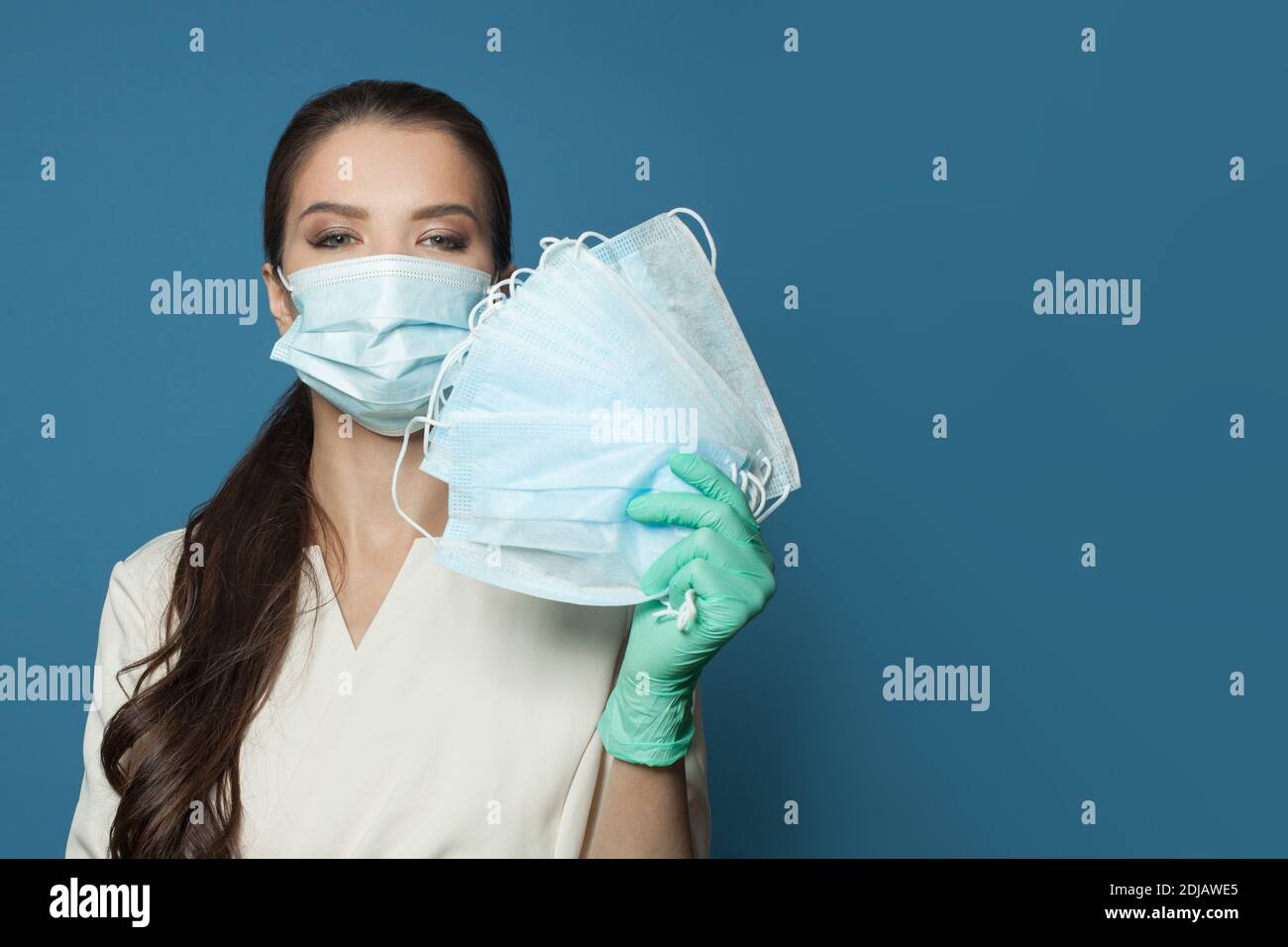 Happy medico con maschera medica protettiva su sfondo blu, medicina, sicurezza e virus covid-19 concetto di protezione Foto Stock