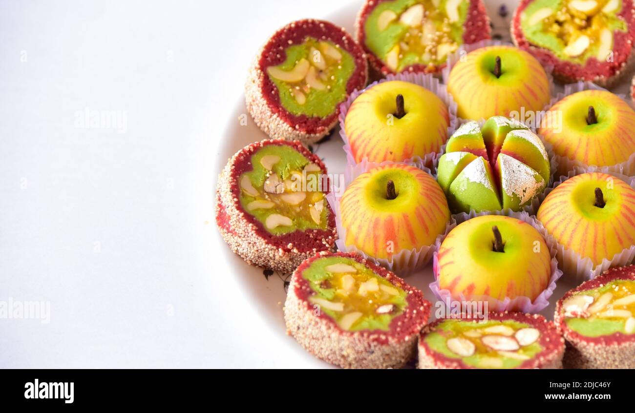 Dolci indiani su un piatto con spazio di copia. Varietà di dolci colorati disposti su un piatto. Foto Stock