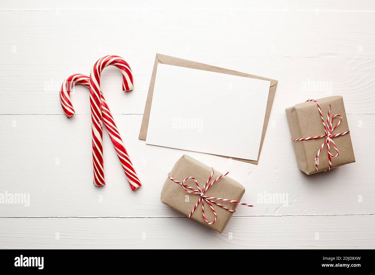 Mockup della carta dei regali di Natale con le scatole del regalo e le  canne delle caramelle su sfondo bianco di legno Foto stock - Alamy
