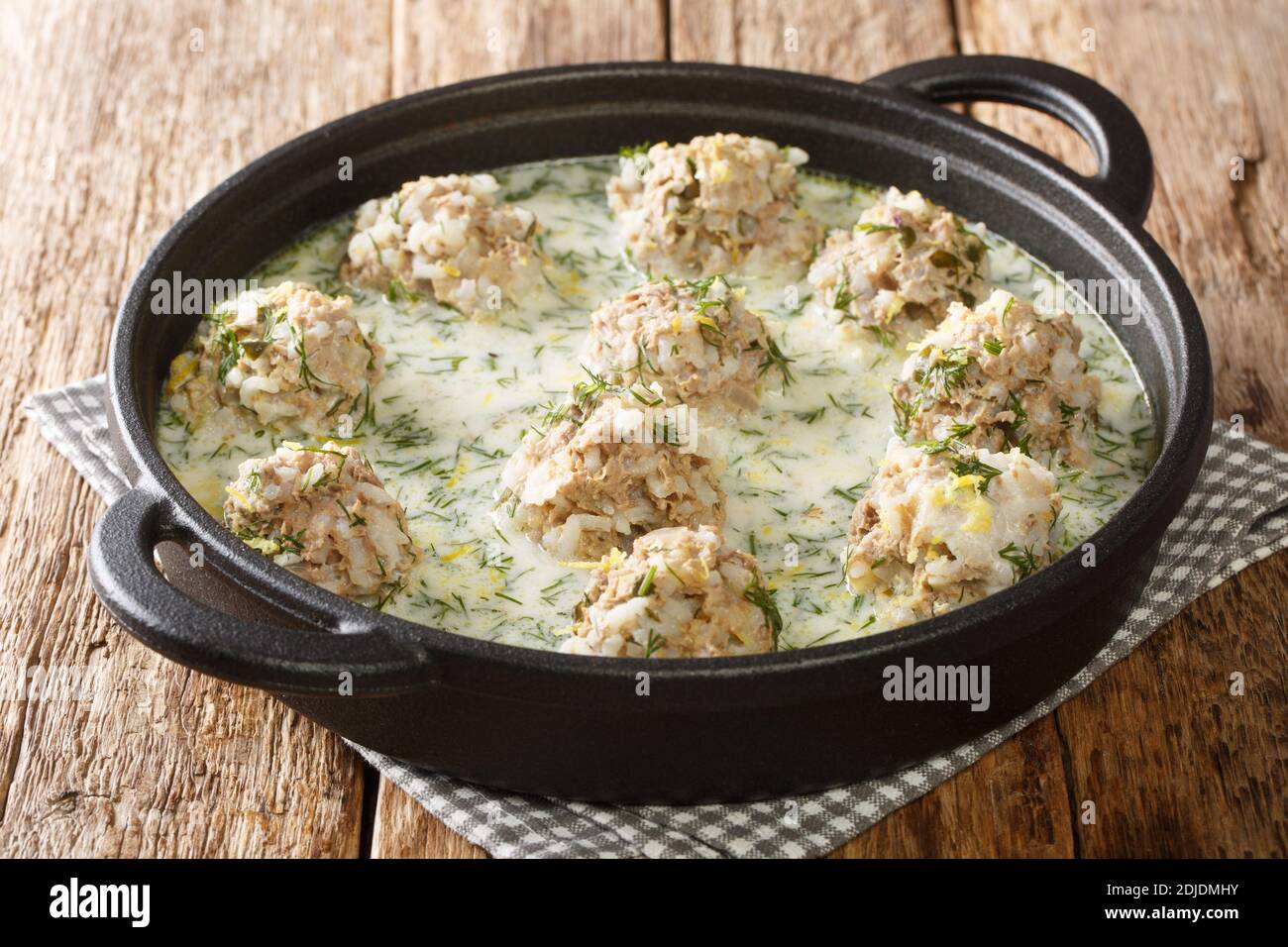 Yuvarlakia o zuppa greca di meatball è un piatto saporito di polpette meravigliosamente condite con salsa da vicino in un piatto sul tavolo. Orizzontale Foto Stock