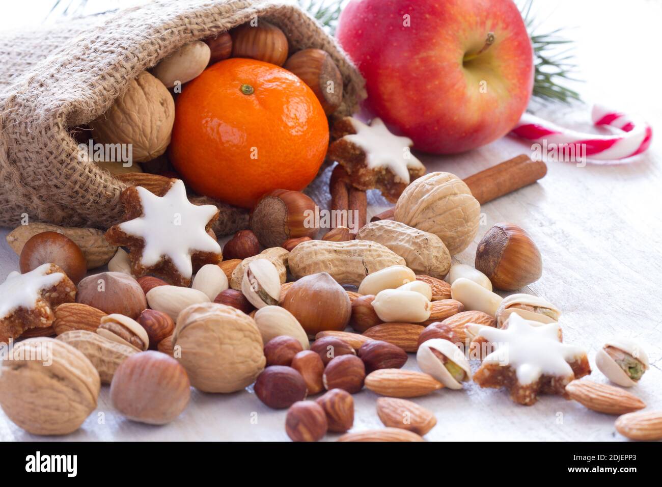 Noci, frutta e biscotti in sacco di iuta, sfondo naturale cibo di natale Foto Stock