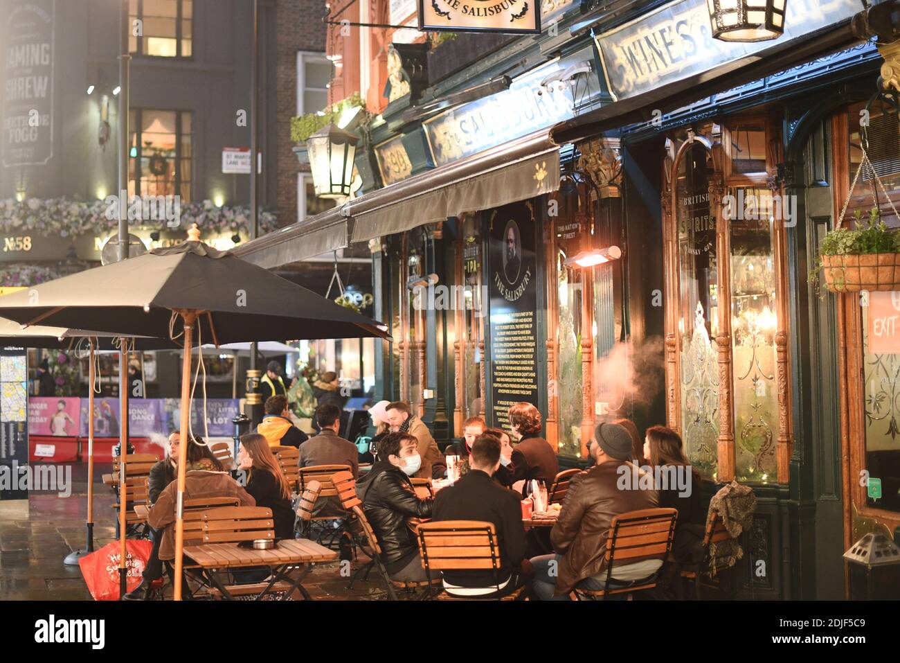 La gente ha seduto fuori di un pub nel West End di Londra dopo l'annuncio che la capitale e le parti di Essex e Hertfordshire affronteranno le restrizioni di livello 3 da mercoledì a seguito di un aumento dei casi di coronaveurs. Foto Stock