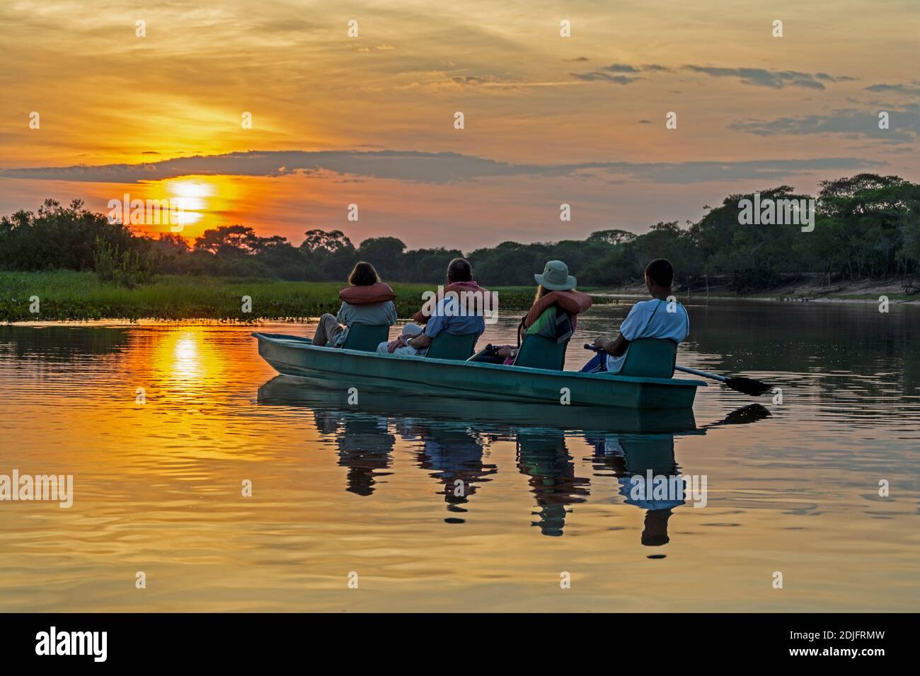 Alba sull'ampio fiume Mutum nel Pantanal AS un piccolo gruppo di turisti pagaia in canoa In una gita di prima mattina alla scoperta della fauna selvatica in B Foto Stock
