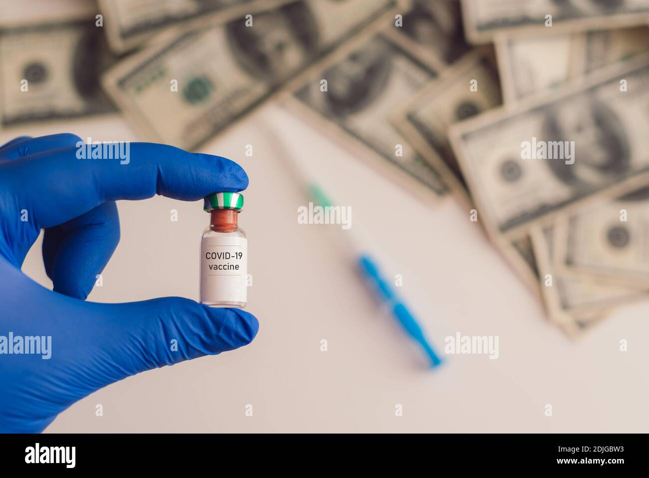 vaccino covid-19 in mano con denaro in background Foto Stock
