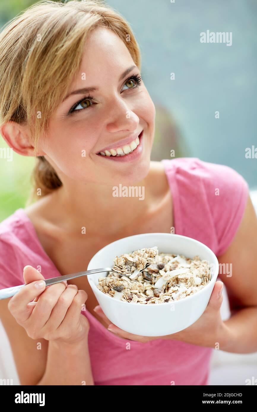 Bella donna che mangia ciotola di cereali Foto Stock