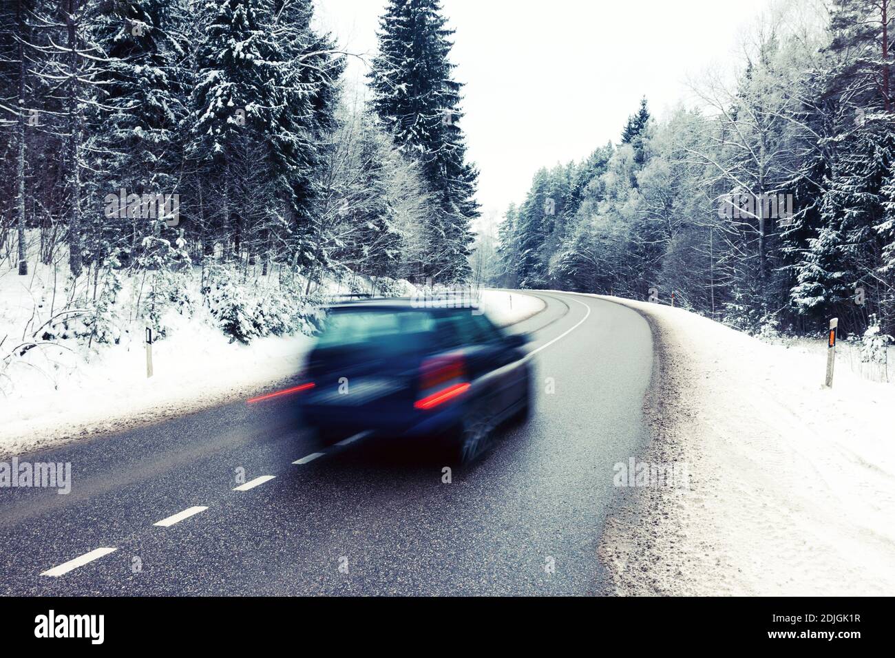 Lonely auto in motion blur su strada nel paesaggio invernale Foto Stock