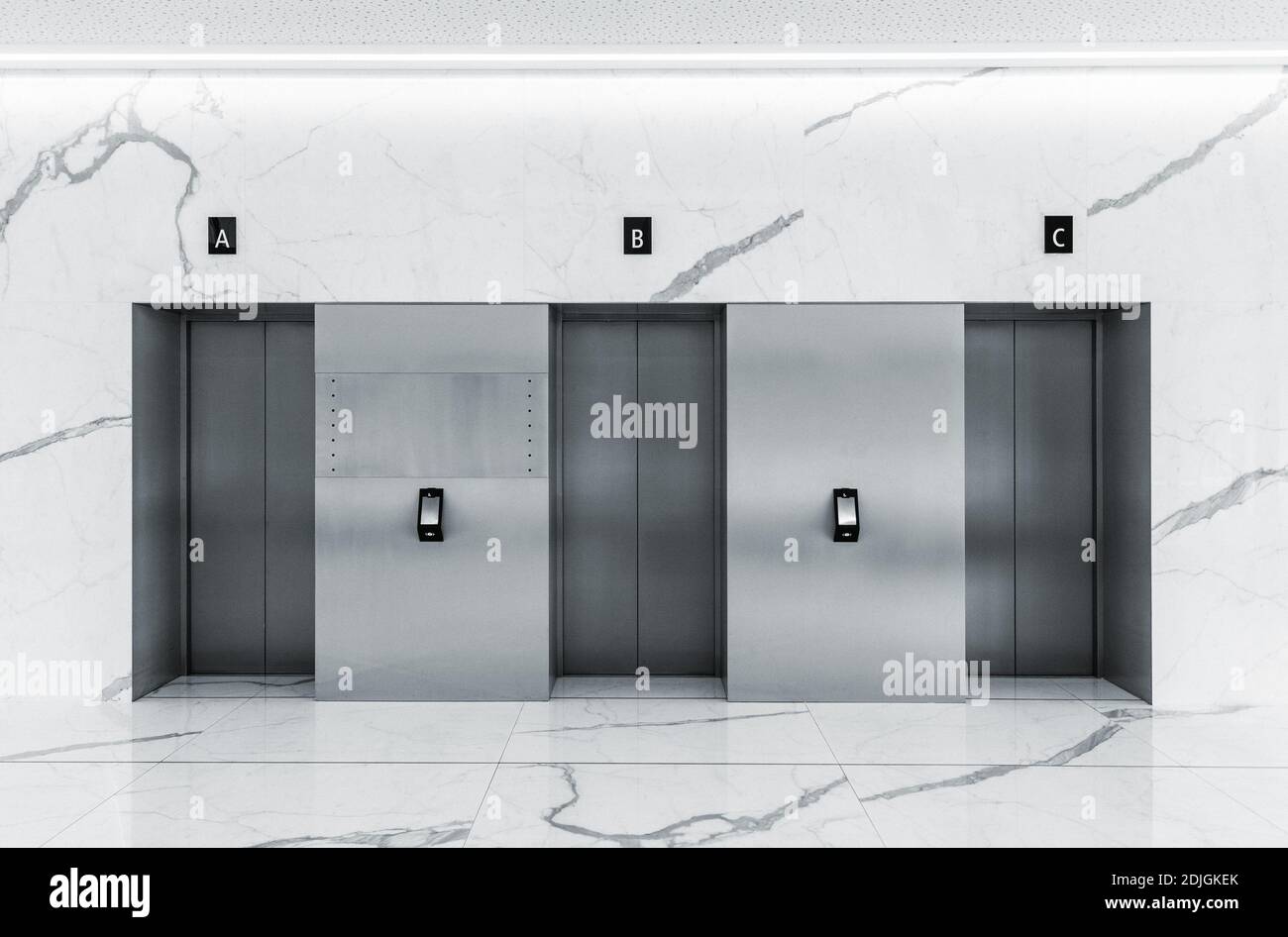 Gli interni moderni e minimalisti della lobby del centro affari con tre camere chiuse in acciaio sollevare gli sportelli Foto Stock