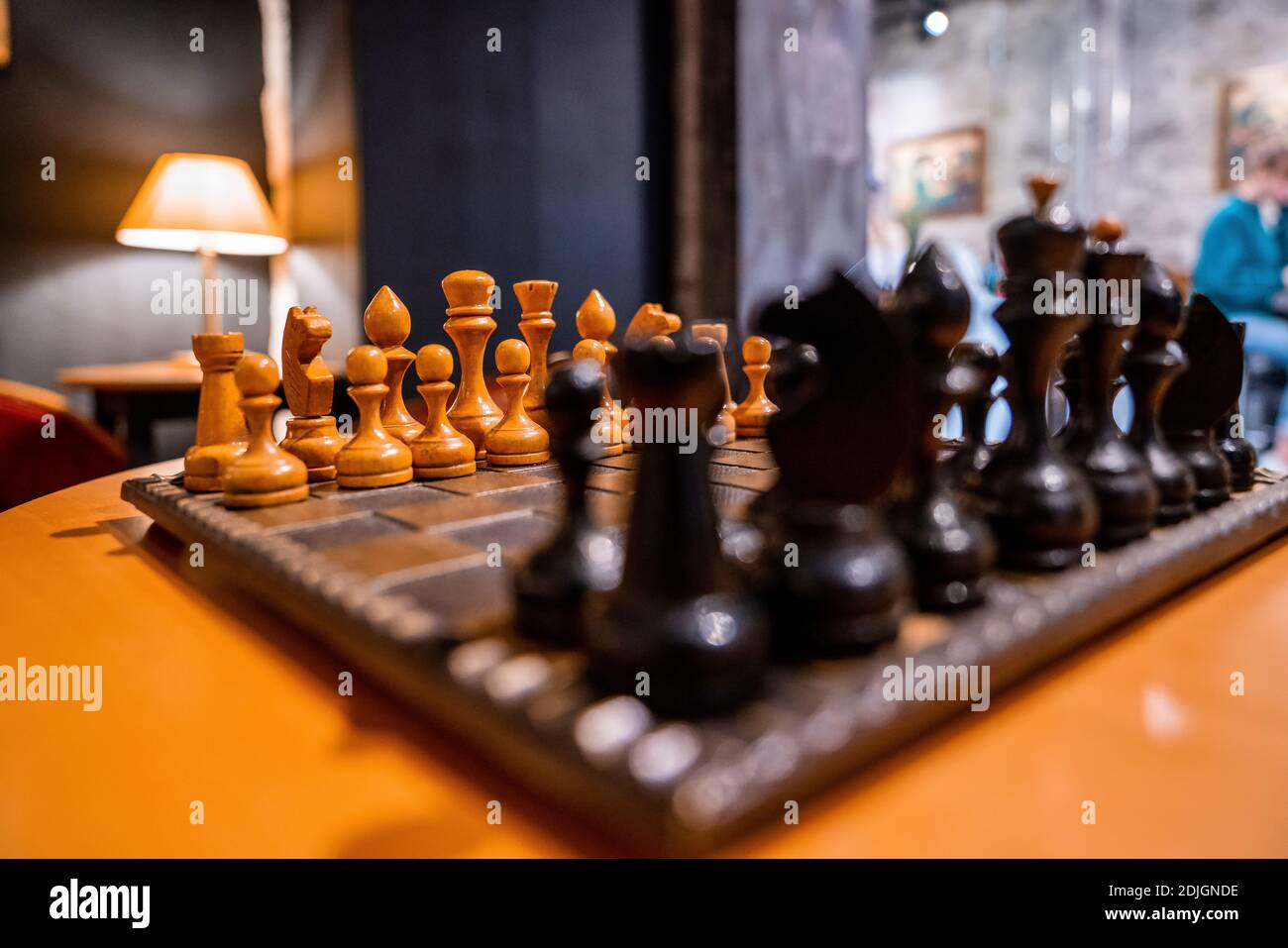 Pezzi di scacchi su scacchiera classica nell'accogliente caffetteria. Foto Stock