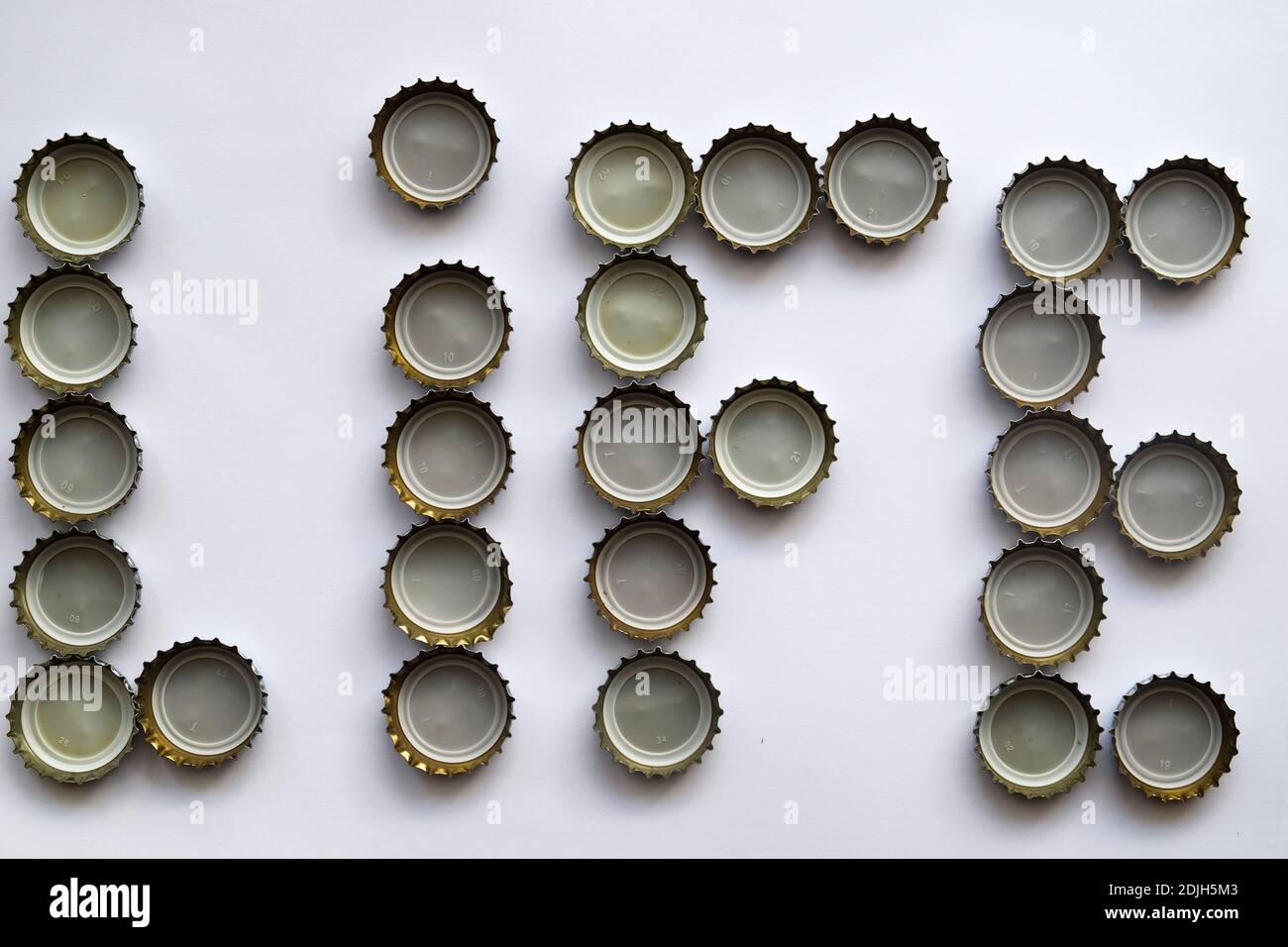 Molti tappi di bottiglia di soda su terra bianca infinita, no alcool sì vita, la parola vita, composto da tappi di alcool, tappi di bottiglia di vetro usati isolati fatti Foto Stock