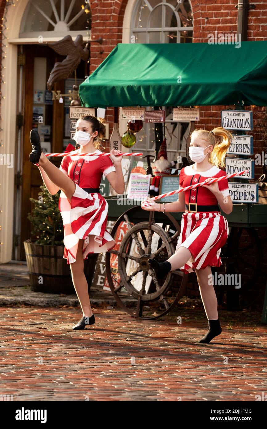 Le ragazze adolescenti eseguono una routine di ballo di Natale indossando maschere nel quartiere storico di Newburyport, Massachusetts, Stati Uniti nel dicembre 2020. Foto Stock