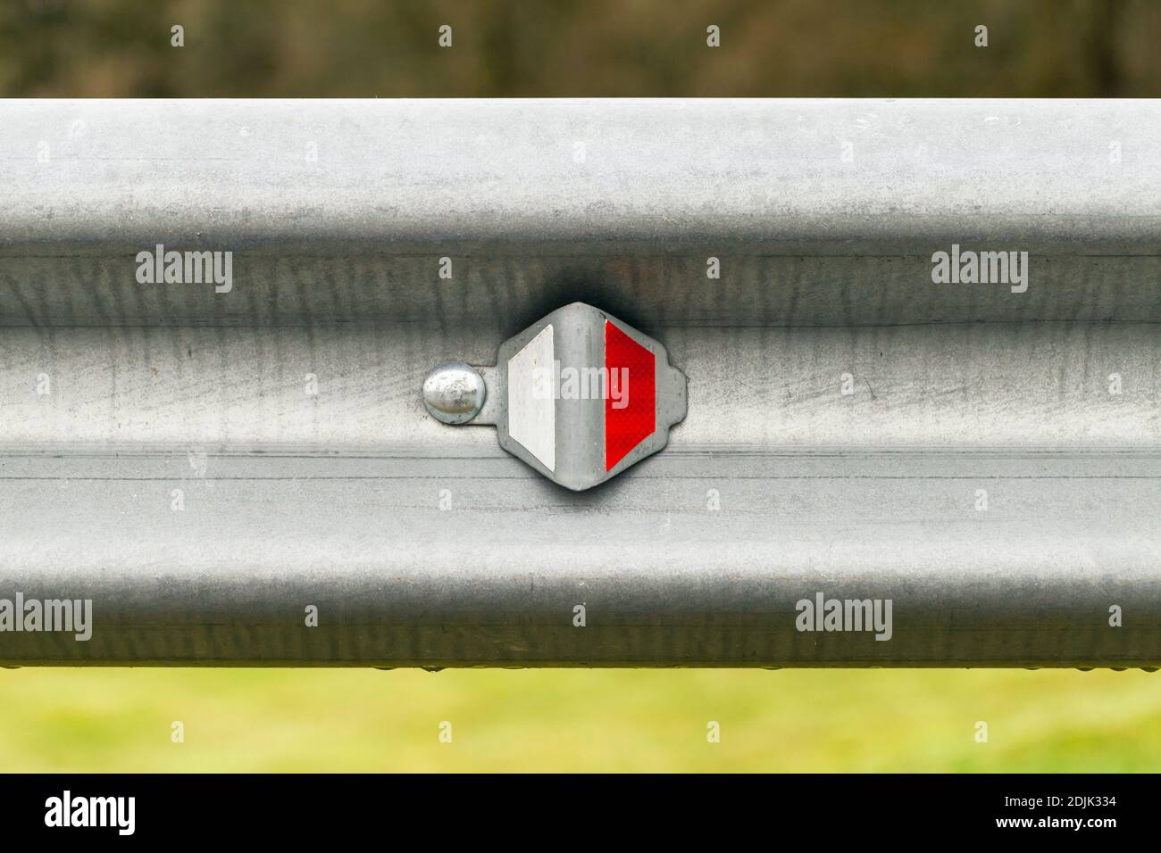 L'unità ottica retroriflettente si trova su una barriera di protezione in metallo. Attrezzature di sicurezza per le autostrade, primo piano Foto Stock