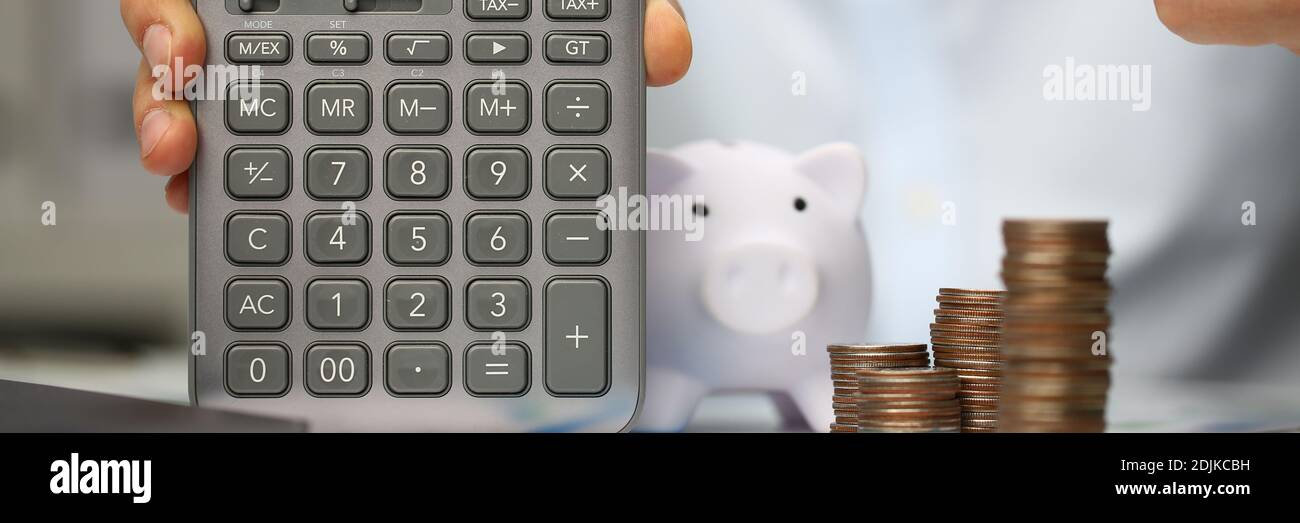 Giovane uomo che punta il dito verso la calcolatrice grigia Foto Stock