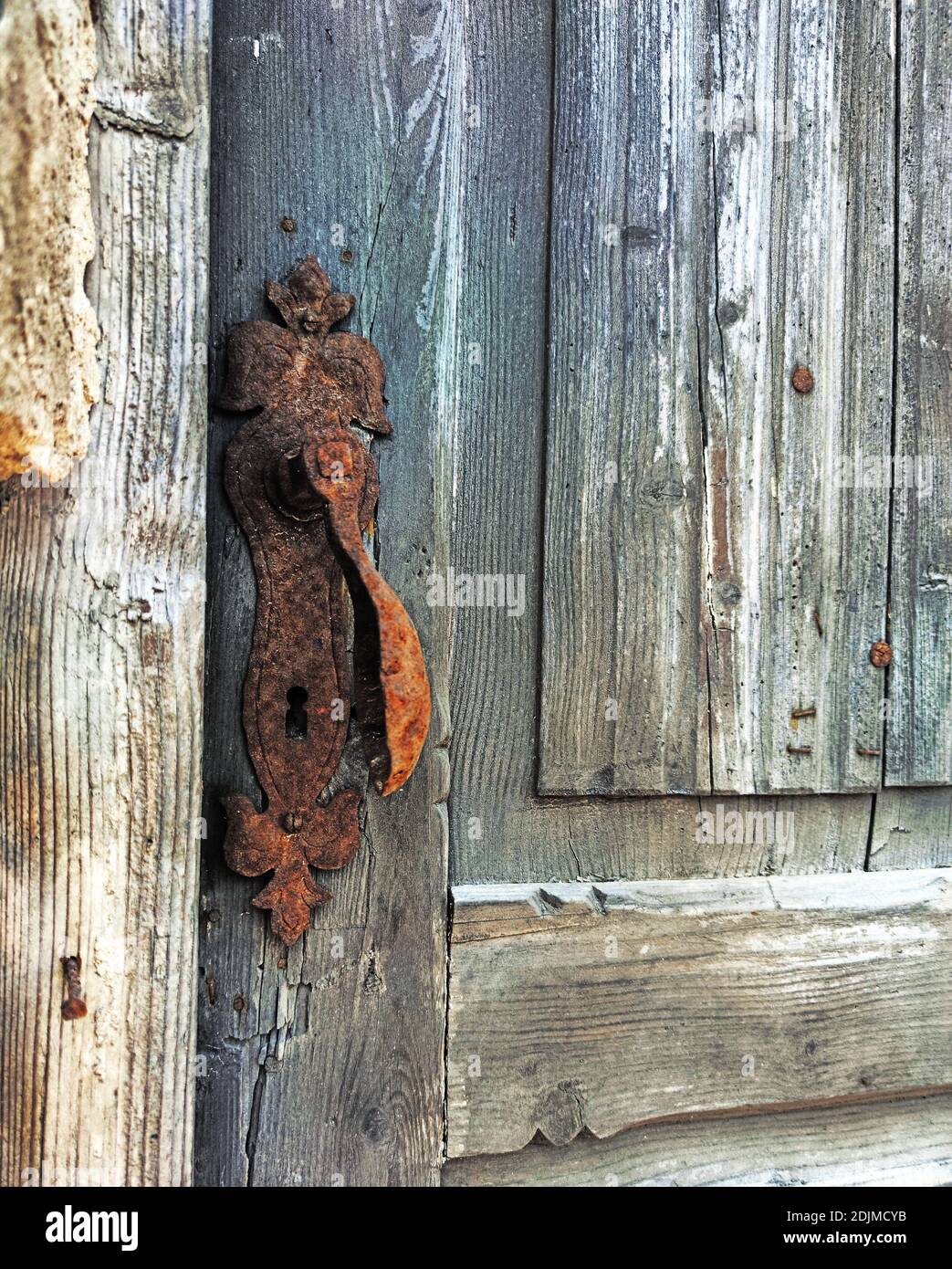 pomolo arrugginito su una vecchia porta di legno Foto Stock