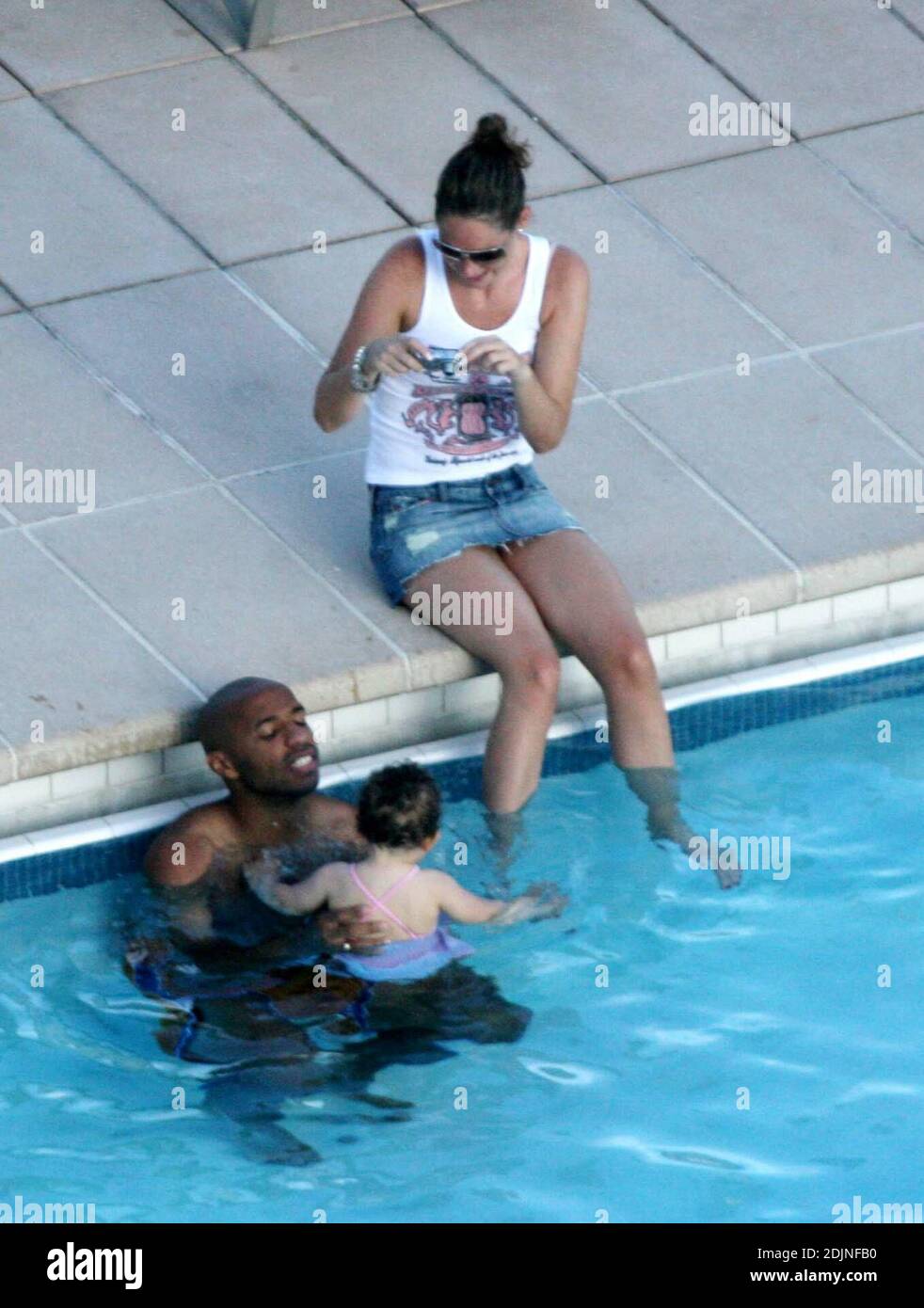 Esclusiva!! Francia e Arsenal calcio asso Thierry Henry dà alla figlia Tea alcune lezioni di nuoto e controllo della palla. La moglie Nicole Merry, che trascorse la mattina prendendo il sole, si guardò e, come qualsiasi mamma orgogliosa, scappò via con la sua fotocamera digitale. Al mattino, Nicole si è soleggiato per un'ora e mezza ogni giorno mentre chiacchiera sul suo cellulare senza sosta, Miami Beach, FL, 7/25/06 Foto Stock