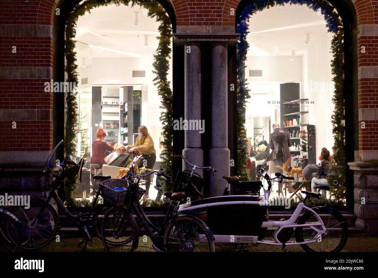 Haarlem, Paesi Bassi. 14 dicembre 2020. La gente è vista in un parrucchiere a Haarlem, i Paesi Bassi, il 14 dicembre 2020. Il governo olandese ha deciso di attuare un rigido blocco nella lotta contro la diffusione del romanzo coronavirus, il primo ministro Mark Rutte ha annunciato lunedì sera durante un discorso televisivo qui dal suo ufficio. Credit: Sylvia Lederer/Xinhua/Alamy Live News Foto Stock