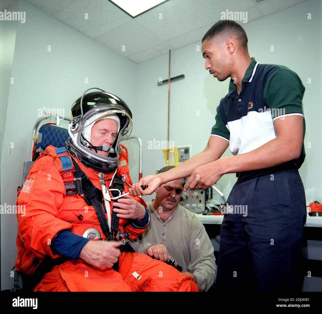 Questa pubblicazione fotografica mostra il senatore degli Stati Uniti John H. Glenn, Jr (democratico dell'Ohio) che è stato aiutato da Lloyd Armintor (centro) di Boeing e Carlous Gillis nel donare il suo lancio di pressione parziale e la tuta di entrata durante l'addestramento al Johnson Space Center a Houston, Texas il 19 aprile 1998. Foto di NASA via CNP/ABACAPRESS.COM Foto Stock