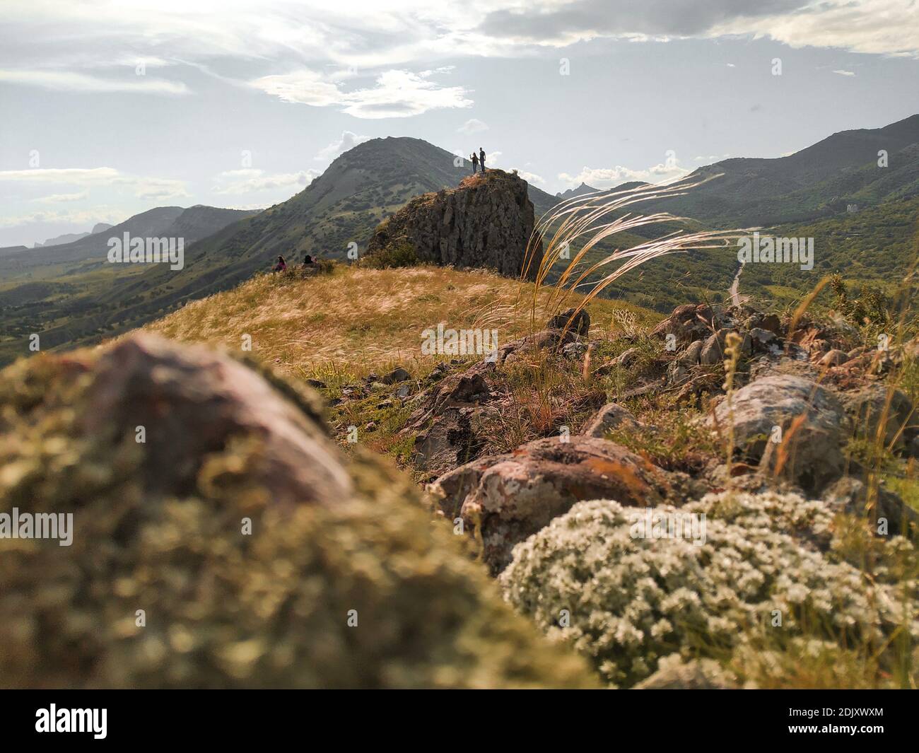Paesaggio estivo con una coppia che guarda il paesaggio sulla roccia. Destinazioni di viaggio e obiettivi escursionistici raggiungimento per una buona salute e corpo forte Foto Stock