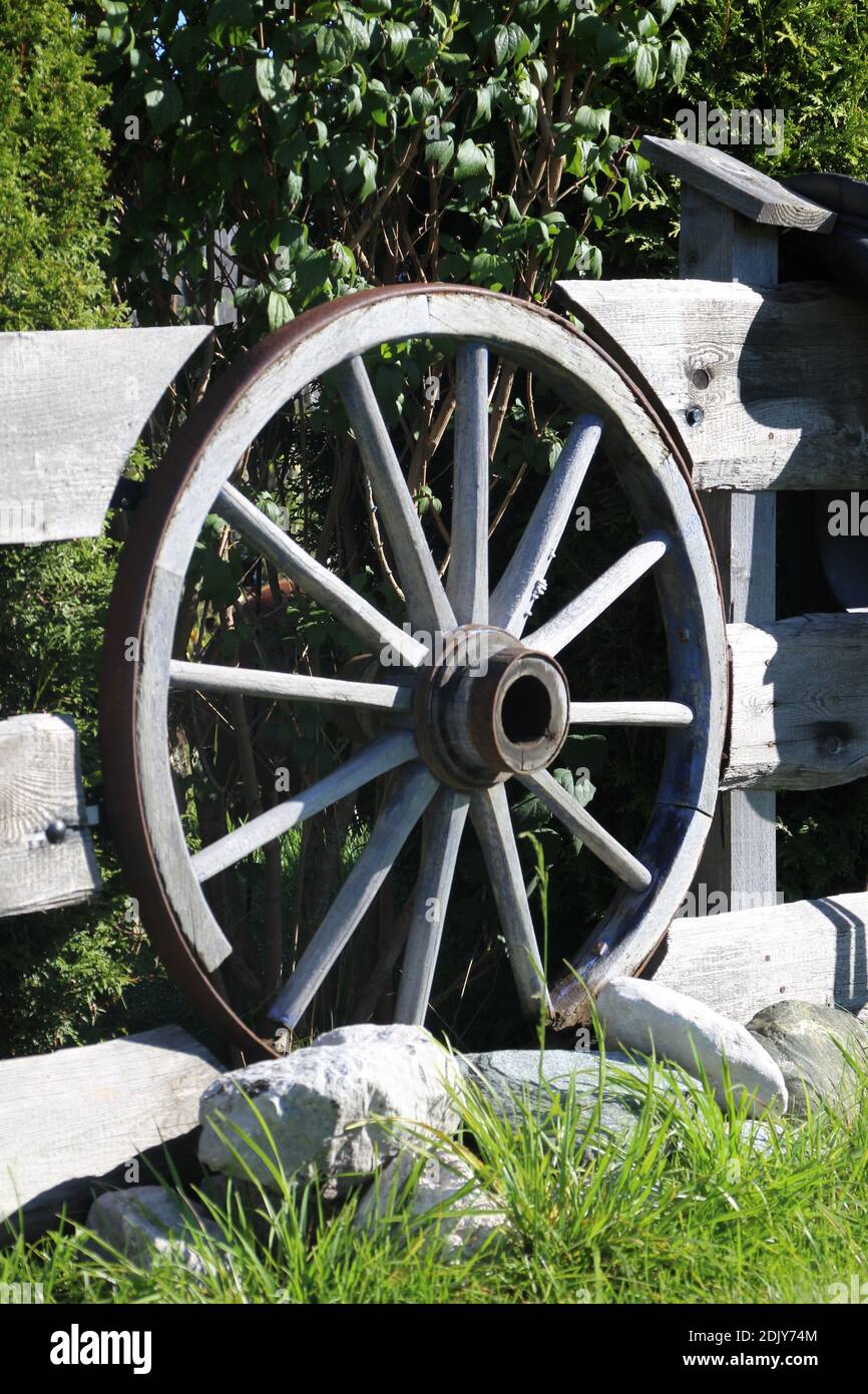 Ruota del carro di decorazione integrata nel recinto di legno, pura vita di campagna nei prati humpback vicino a Mittenwald Foto Stock