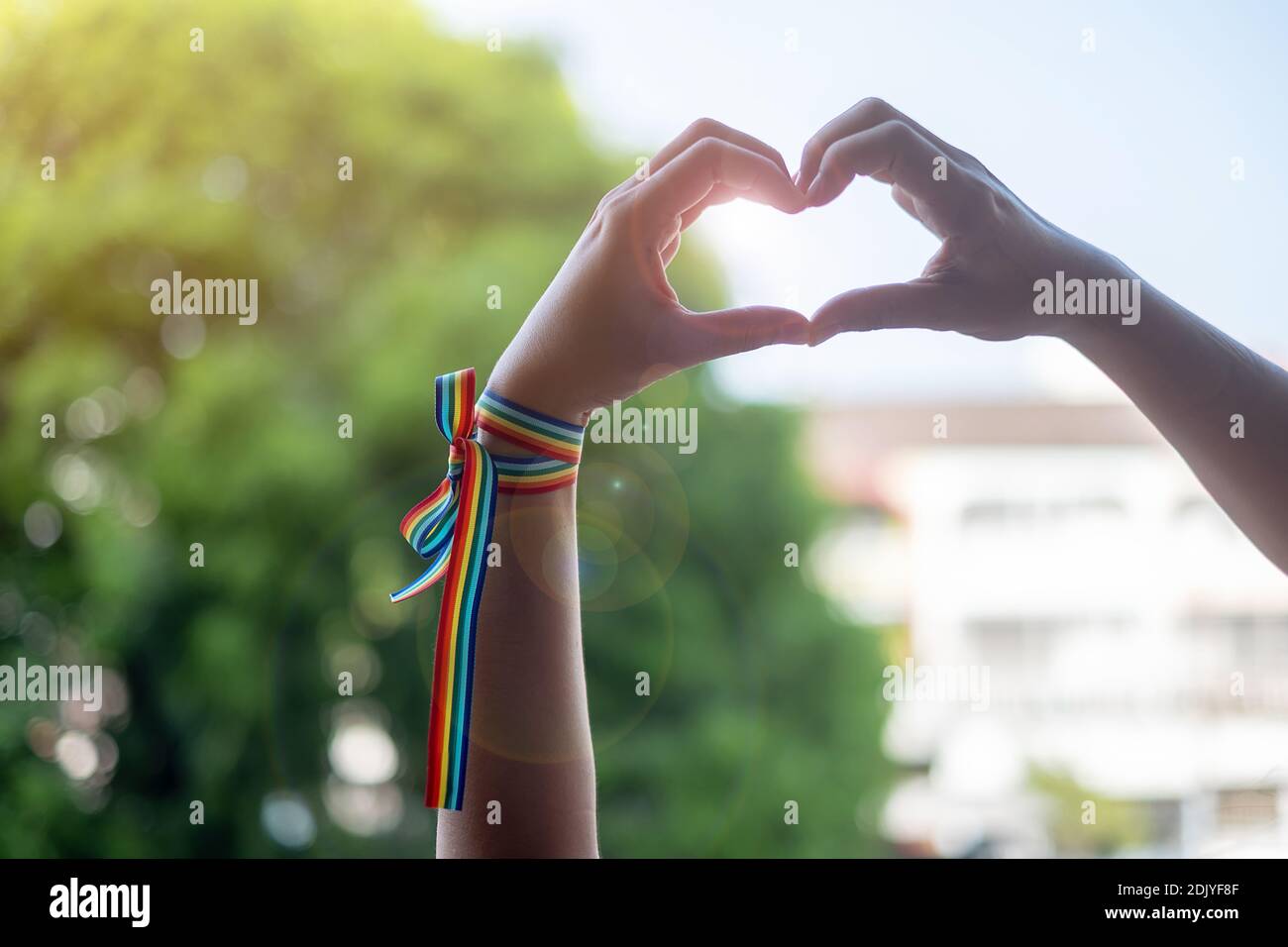 Vista ad angolo basso delle mani che creano una forma cardiaca all'aperto Foto Stock