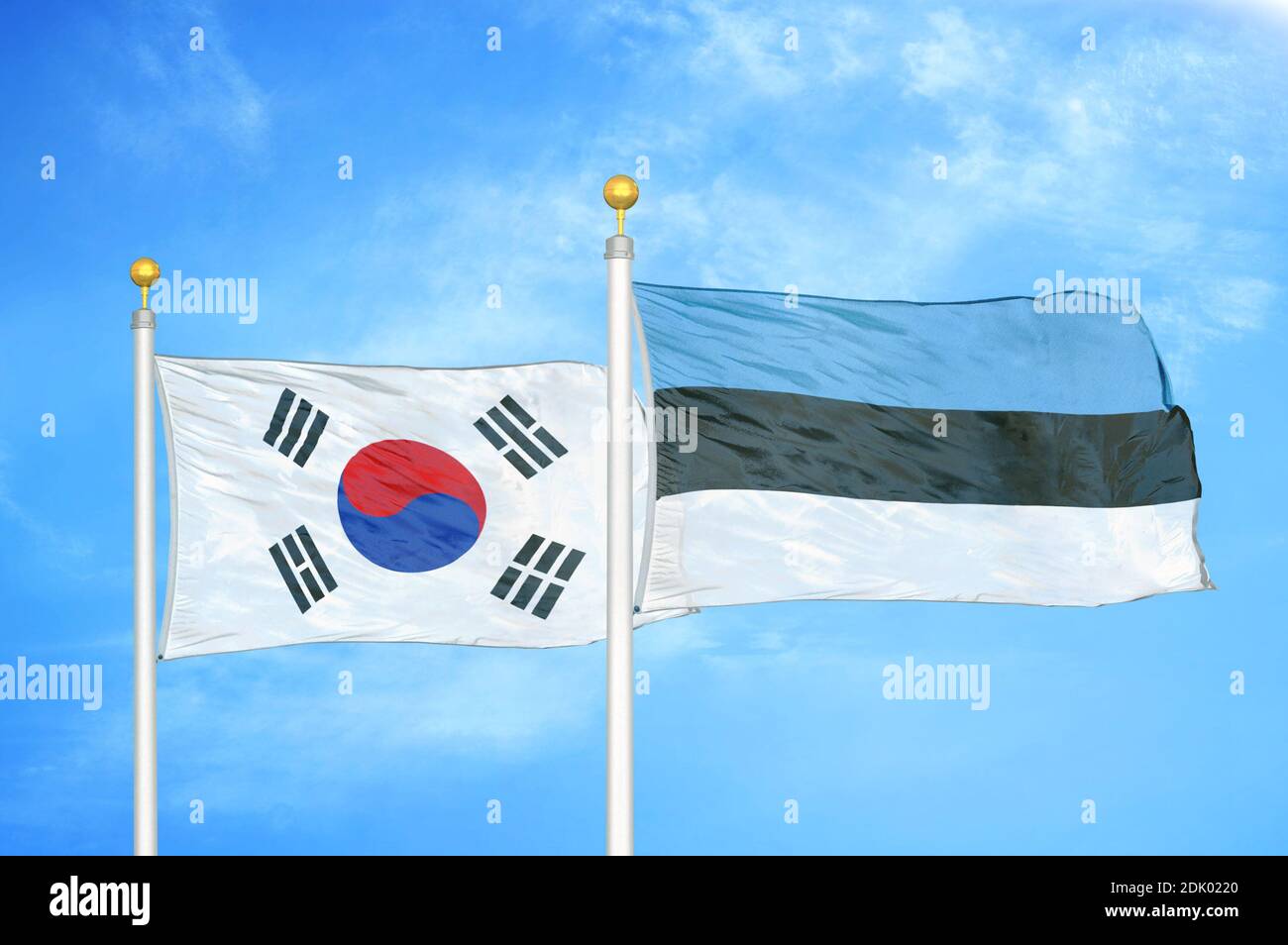 Corea del Sud ed Estonia due bandiere su flagpoli e blu cielo nuvoloso Foto Stock