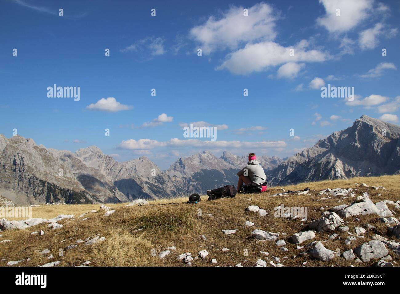 Donna seduta di fronte a una montagna sullo sfondo di Brunnsteinanger Con vista sulla valle del Karwendel Foto Stock