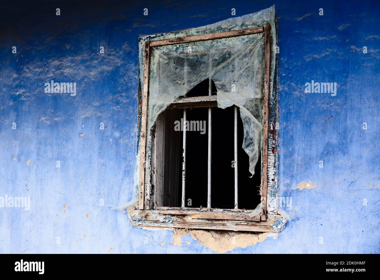 Parete blu con finestra vecchia. Casa abbandonata in rovina Foto Stock