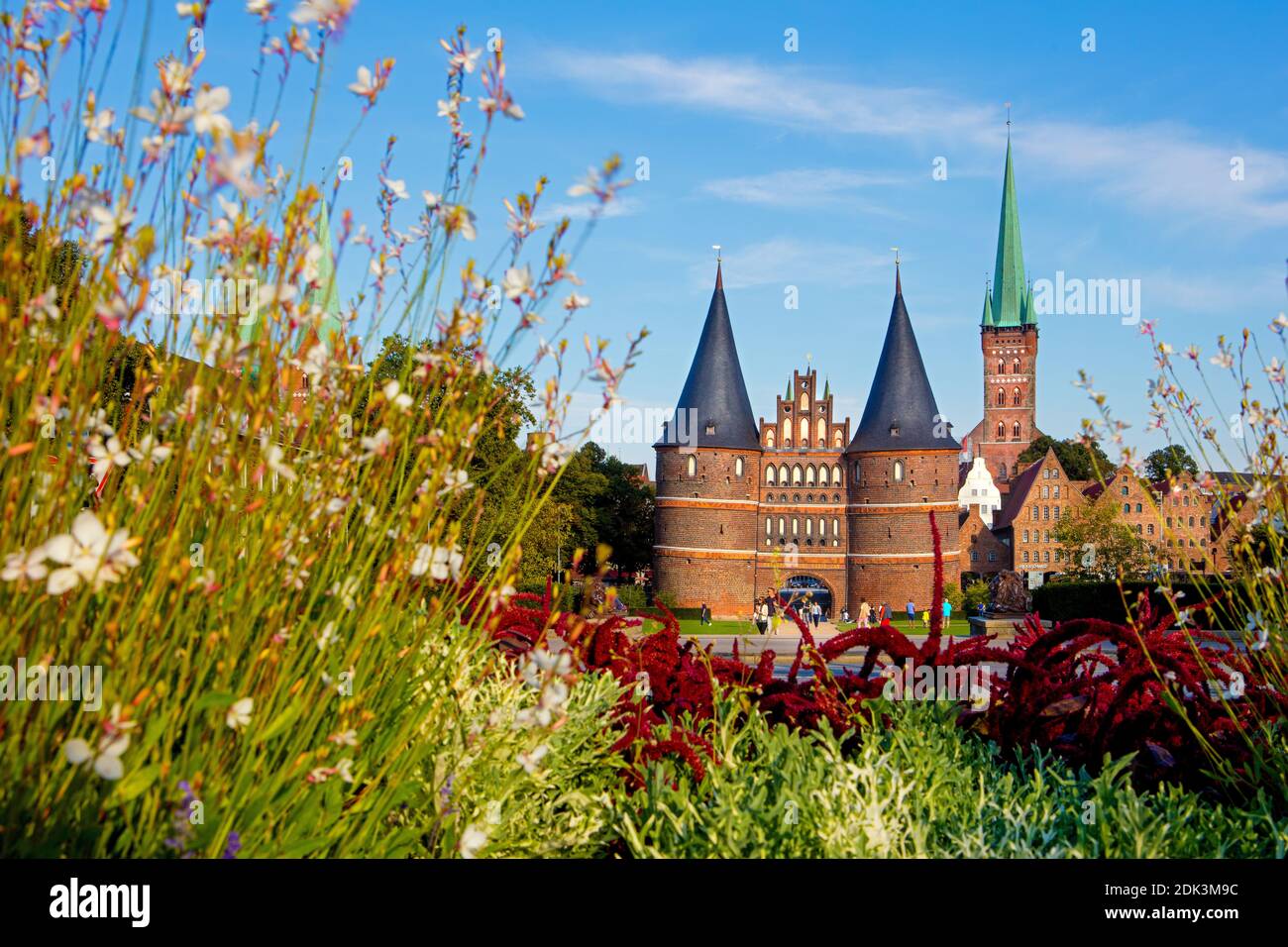 Germania, Schleswig-Holstein, Città anseatica di Lübeck, Vista della porta di Holsten, l'edificio in mattoni è anche il punto di riferimento della città, sullo sfondo il vecchio negozio di sale e la torre di San, Chiesa di Petri, Foto Stock