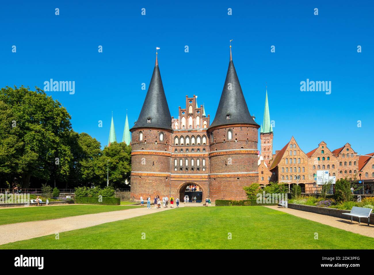 Germania, Schleswig-Holstein, Città anseatica di Lübeck, Vista della porta di Holsten, l'edificio in mattoni è anche il punto di riferimento della città, sullo sfondo le vecchie saline e le torri della Marienkirche e St, Petri Chiesa, Foto Stock