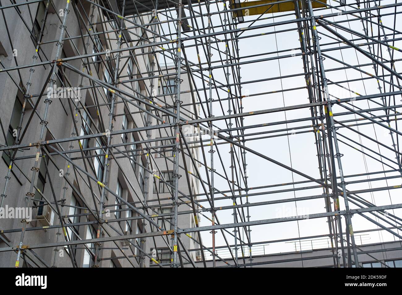 Cantiere dell'edificio. Ampia impalcatura che fornisce piattaforme per lavori in corso su un alto edificio in costruzione con ponteggi. Foto Stock