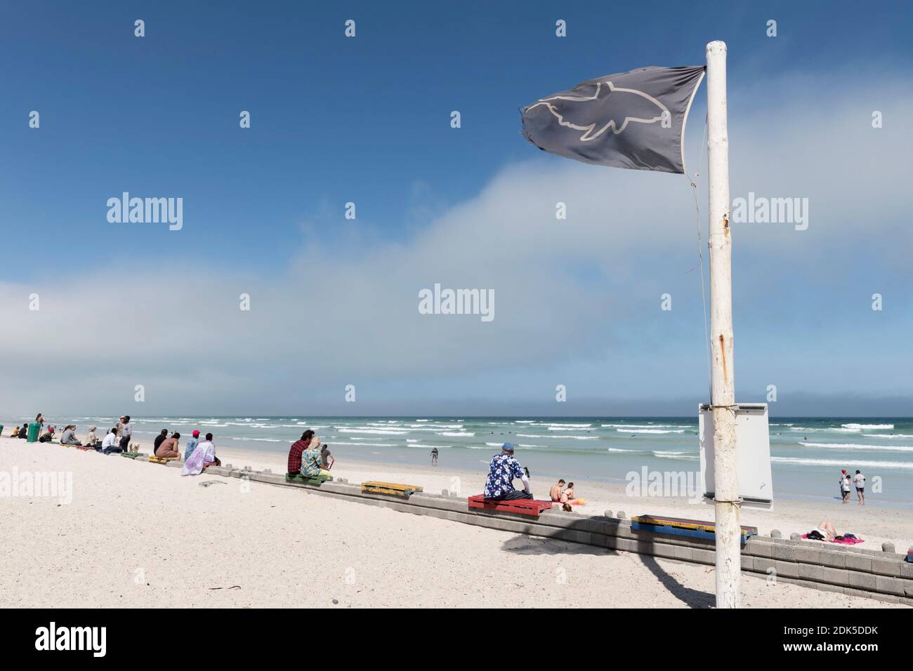 Una bandiera nera di allarme squalo vola sulla spiaggia di Muizenberg, Città del Capo, Sud Africa. La bandiera nera indica che le condizioni di avvistamento degli squali sono scarse. Foto Stock