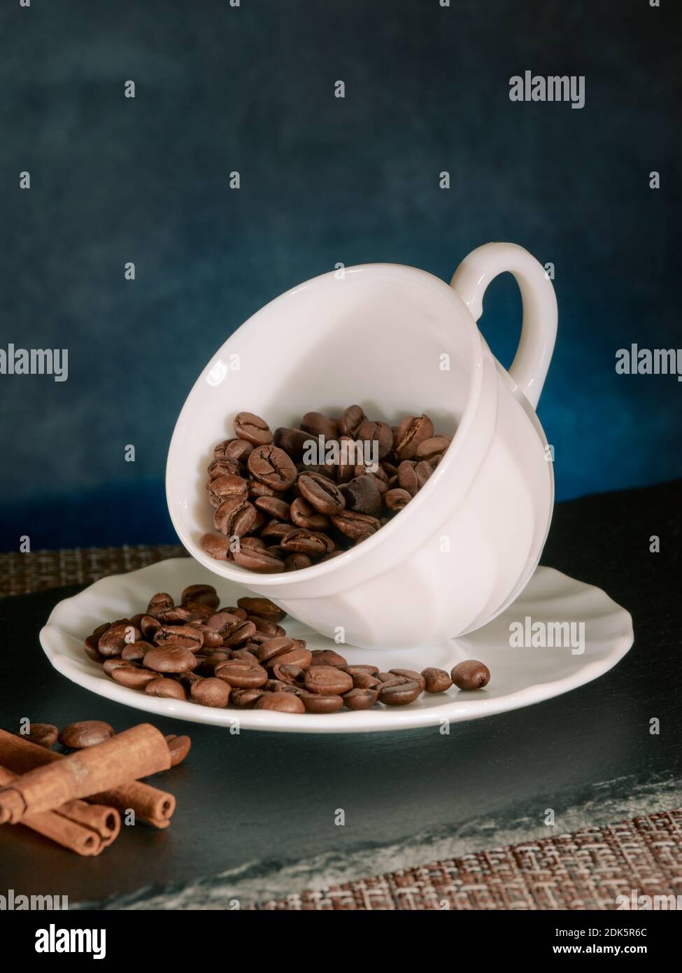 Caffè in grani tostati con bastoncini di cannella in tazza di ceramica  bianca sfondo blu Foto stock - Alamy