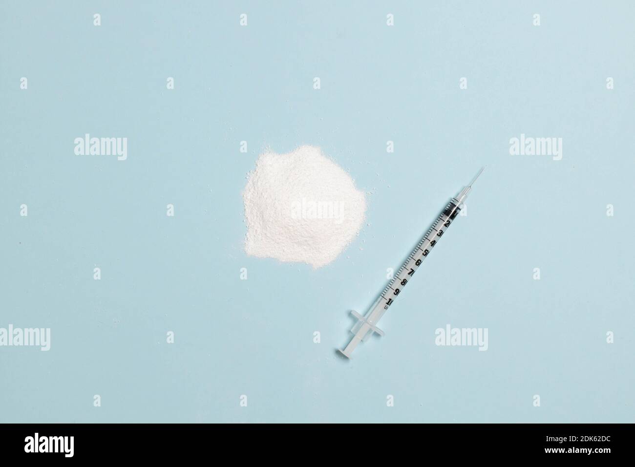 Cocaina narcotica o polvere di eroina e siringa blu sfondo con spazio di copia Foto Stock