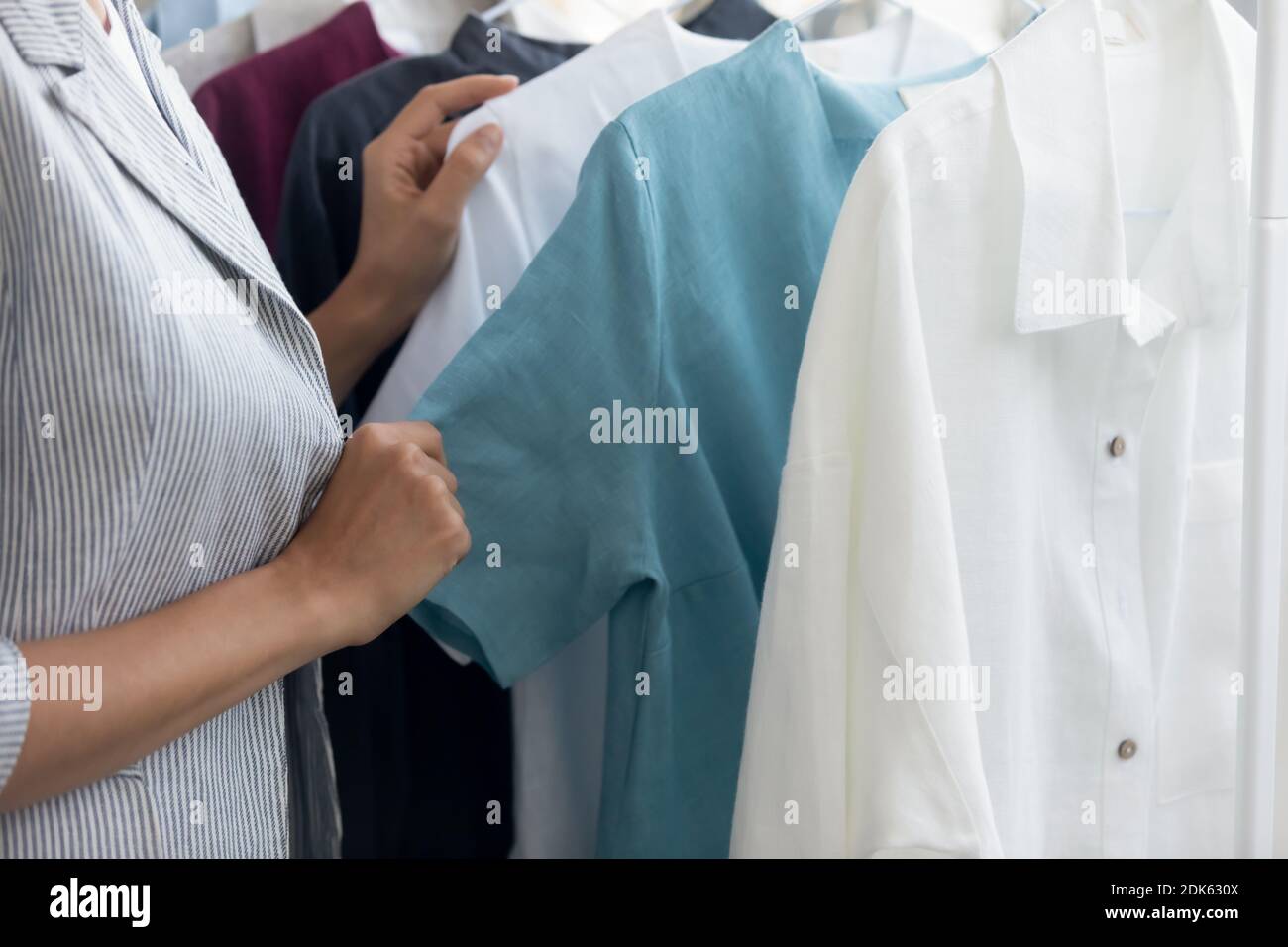 Cliente femminile del negozio di abbigliamento scegliendo i vestiti dalla nuova collezione Foto Stock