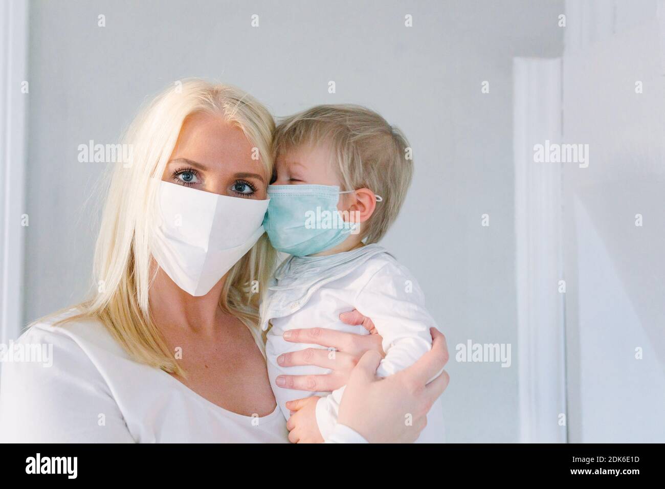 La madre e il figlio abbracciano le maschere per il viso Foto Stock