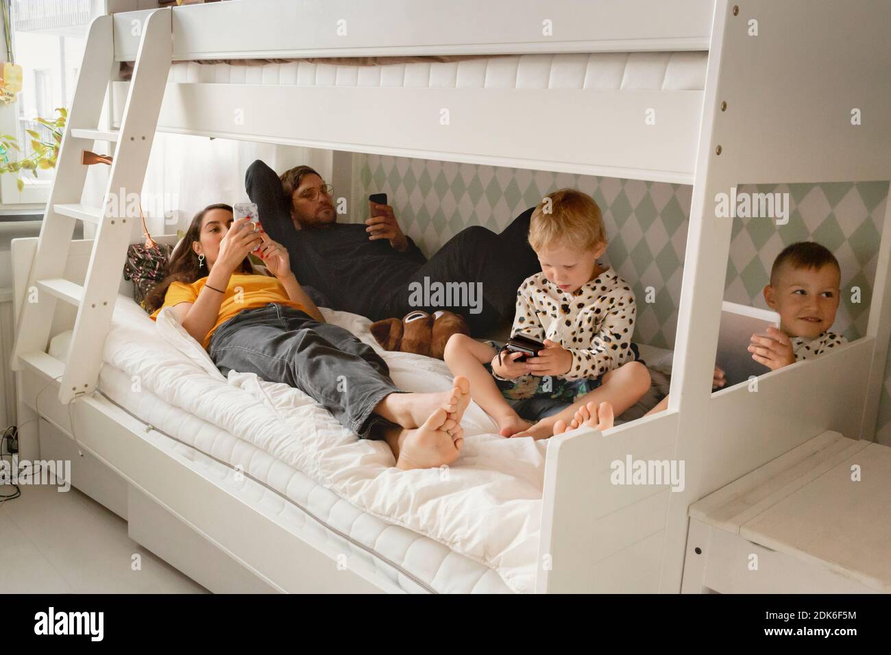 Genitori con figli a letto Foto Stock