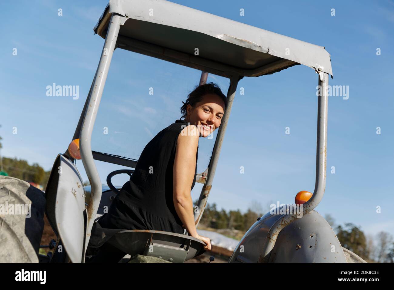 Donna di guidare il trattore Foto Stock