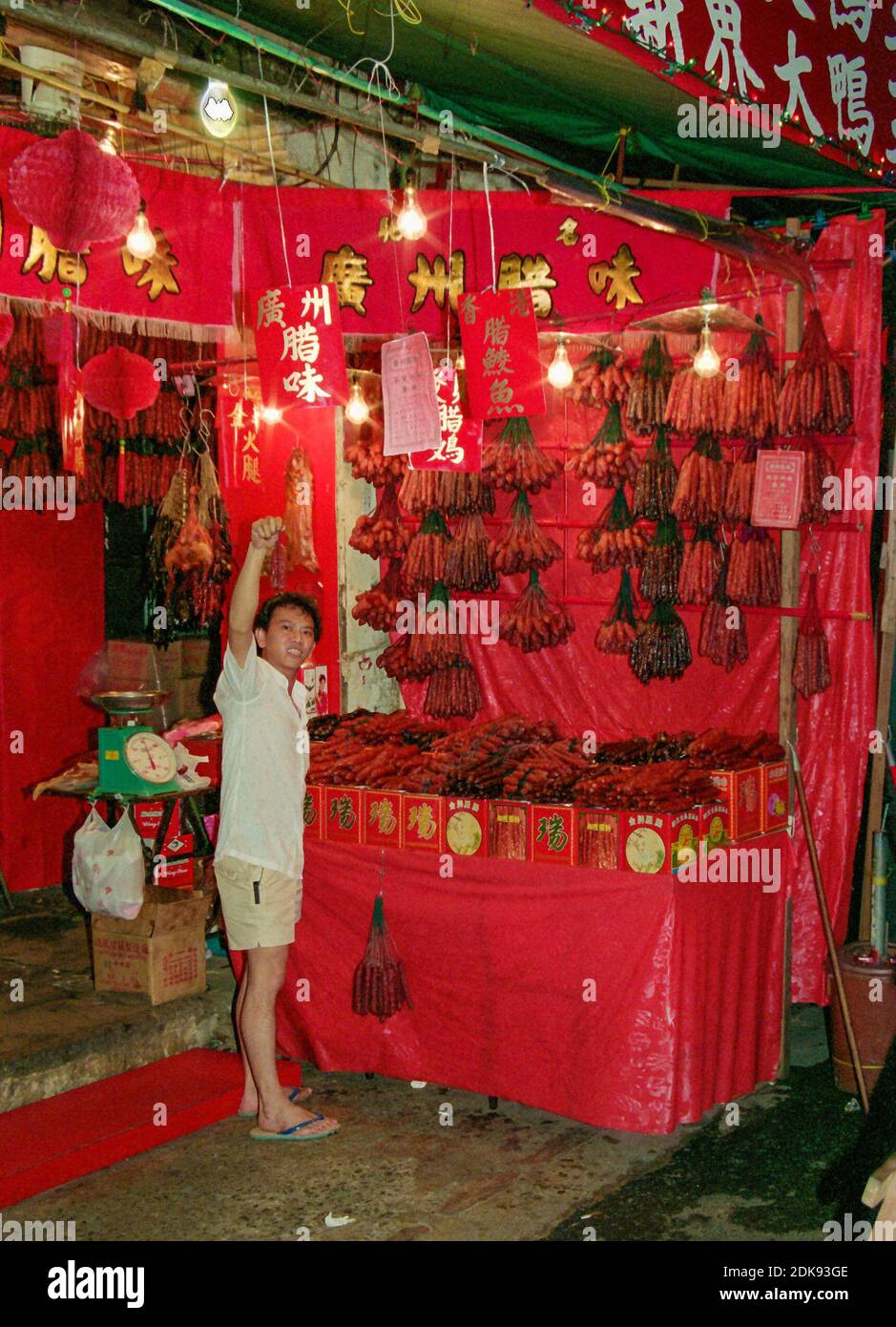 Stallholder cinese che vende le salsicce tradizionali di capodanno, Singapore Foto Stock