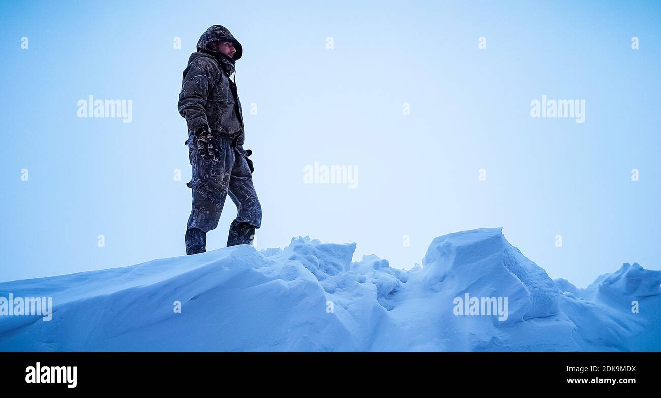 Vista ad angolo basso dell'uomo sulla neve contro il cielo limpida Foto Stock