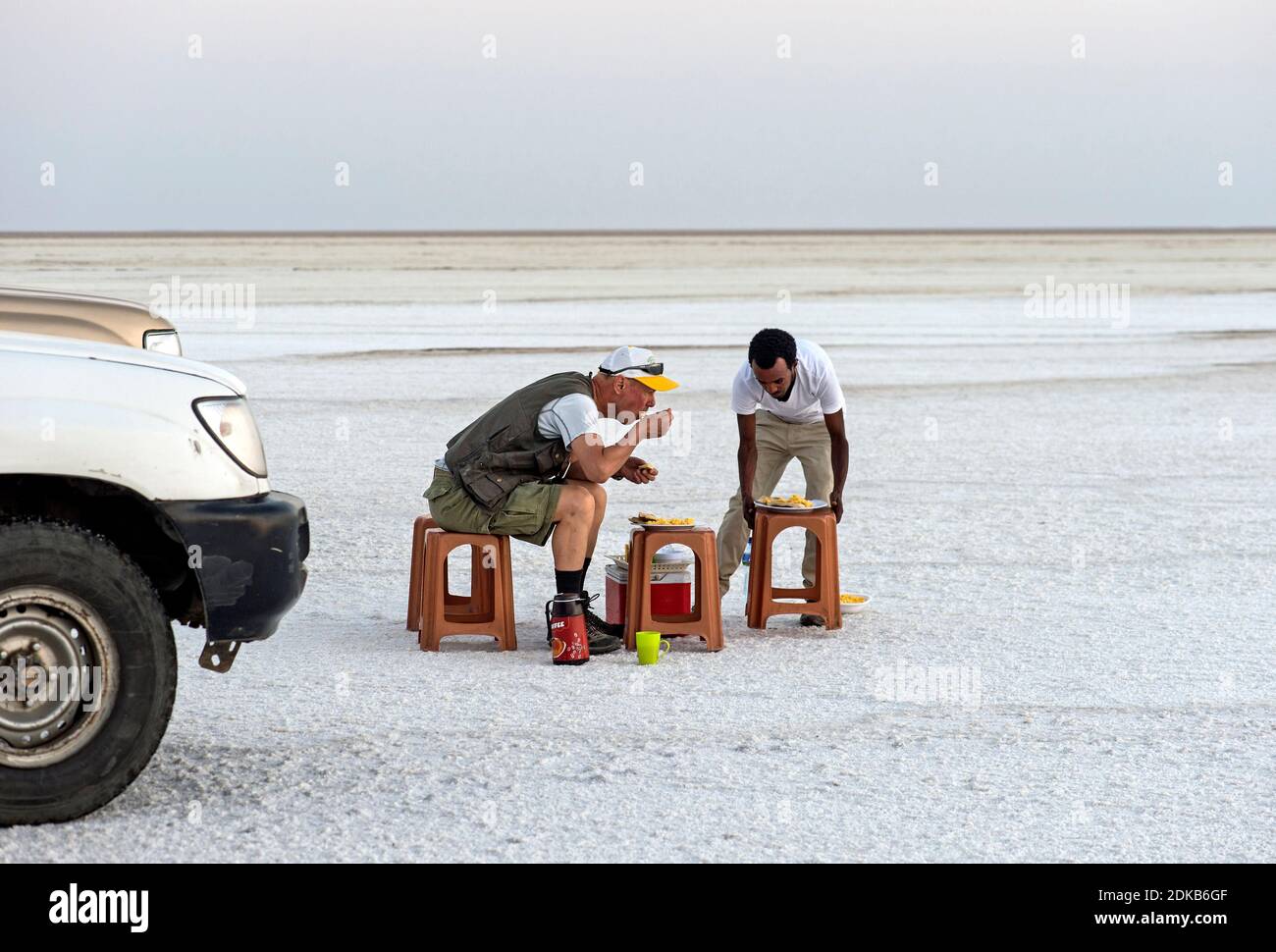 Guida turistica e locale che ha un picnic sul lago salato di Assale vicino Hamadela, depressione di Danakil, Triangolo di Afar, Etiopia Foto Stock