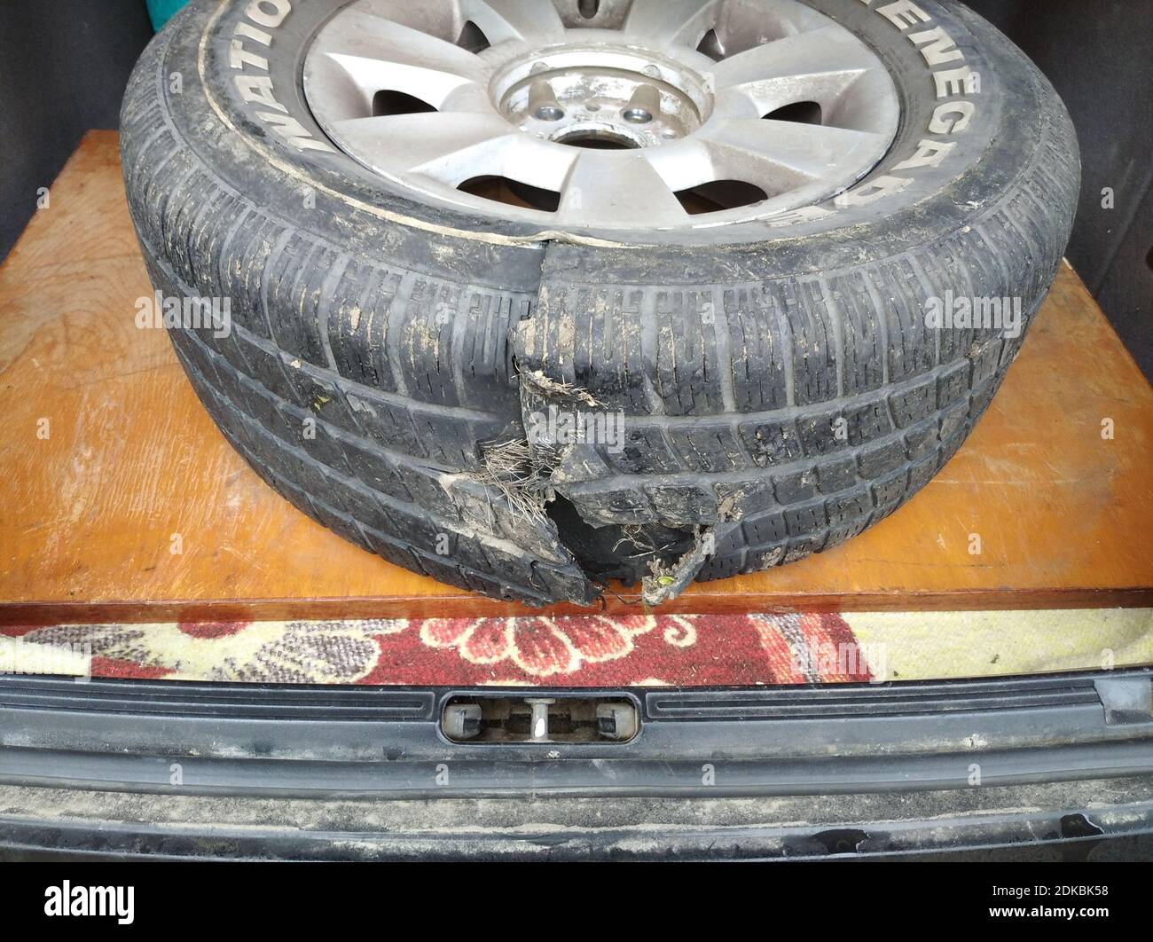 Lo pneumatico danneggiato bruciato della ruota dell'auto si trova all'interno il bagagliaio Foto Stock
